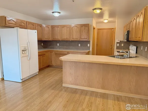 a kitchen with stainless steel appliances granite countertop a refrigerator a sink and a stove