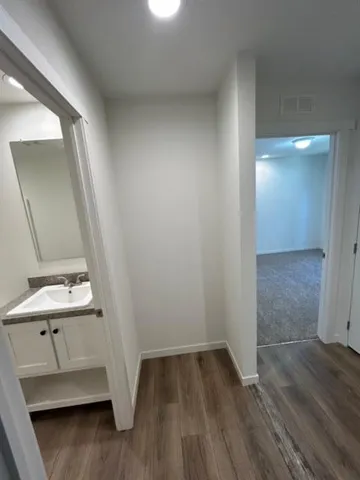 an empty room with wooden floor and mirror