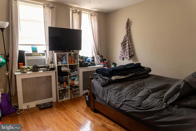 a bed sitting in a bedroom and wooden floor