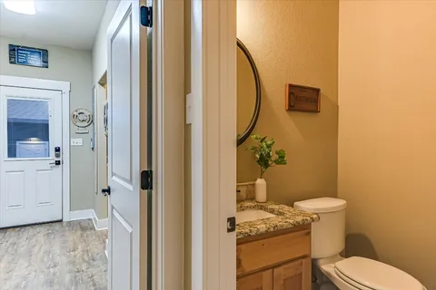 a bathroom with a granite countertop toilet and a sink