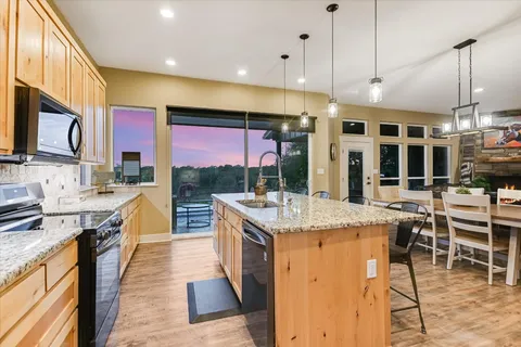 a kitchen with stainless steel appliances granite countertop a stove and cabinets