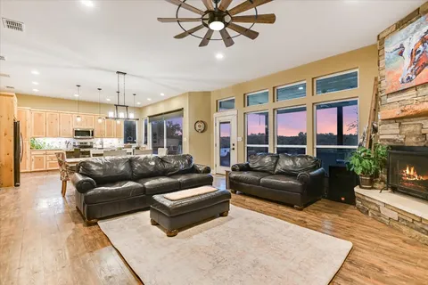 a living room with furniture kitchen view and a large window
