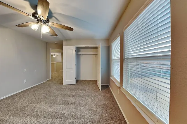 a view of a livingroom with a ceiling fan and window