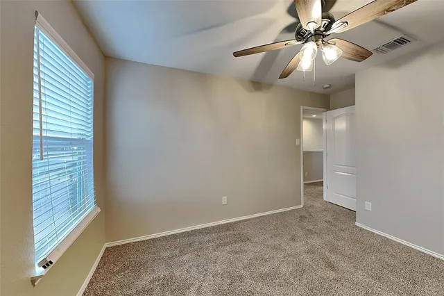 en empty room with windows and fan