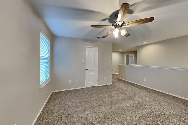 an empty room with windows and fan