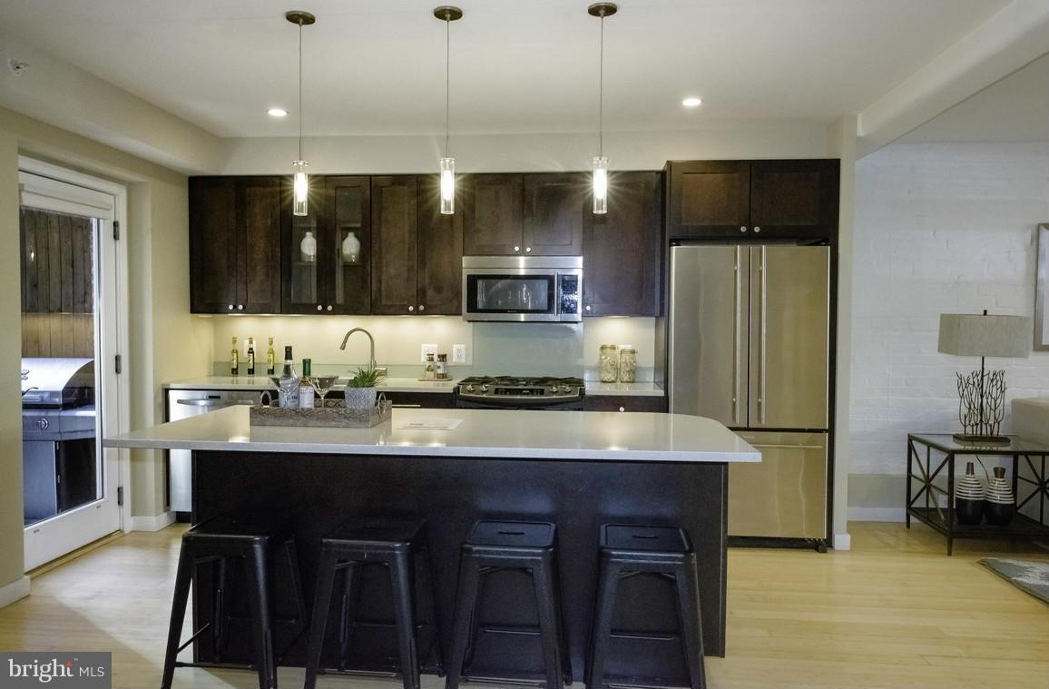 1632 S Street Northwest, Unit 1 Washington, DC 20009 - Photo 3 of 11 a kitchen with stainless steel appliances granite countertop a sink refrigerator and cabinets