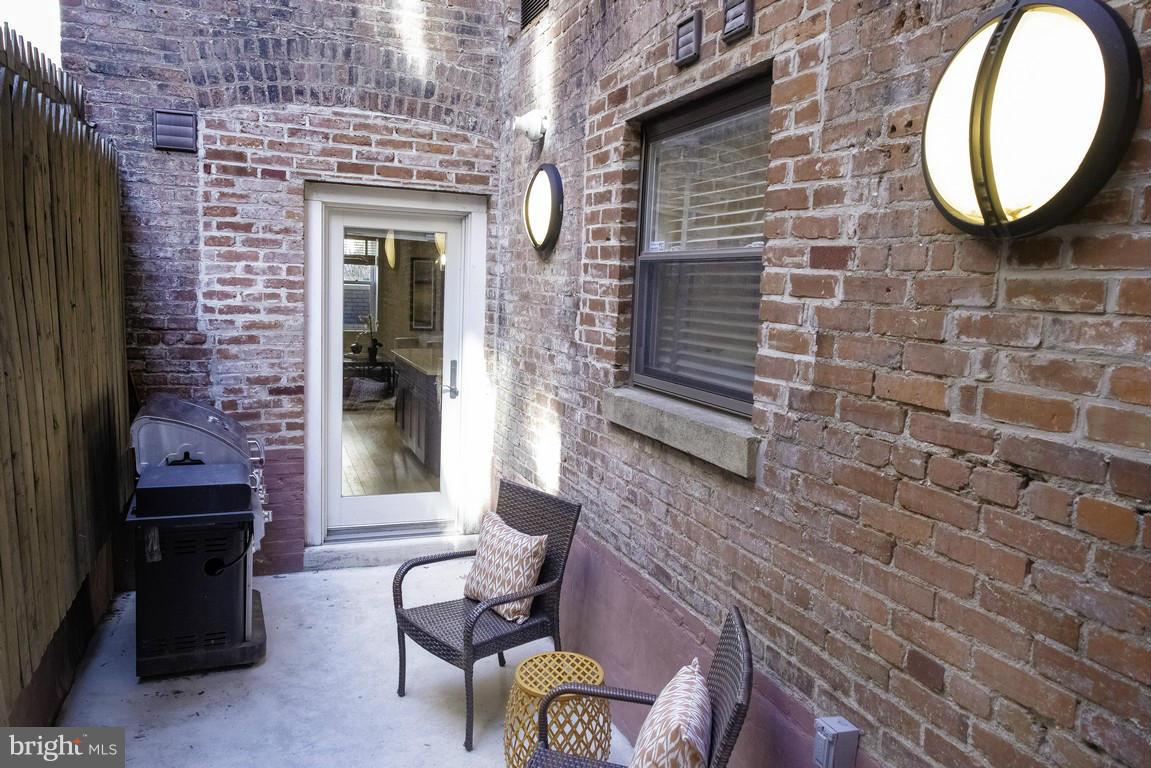 1632 S Street Northwest, Unit 1 Washington, DC 20009 - Photo 10 of 11 a brick building with a bench and a potted plant