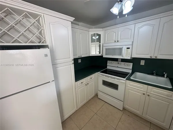 a kitchen with white cabinets and white appliances