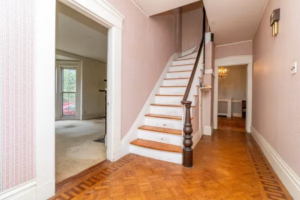 a view of a hallway with wooden floor and entryway