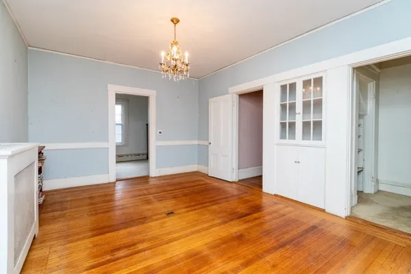 a view of an empty room with wooden floor and staircase