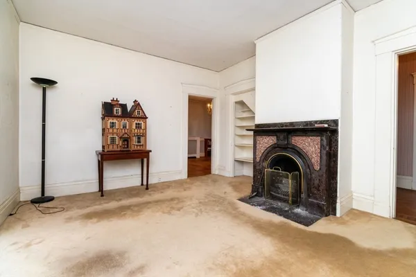 a view of empty room with fireplace and fan