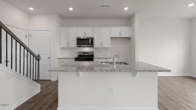 a kitchen with stainless steel appliances granite countertop a sink a stove and a refrigerator