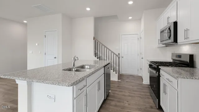 a kitchen that has a sink a stove and oven