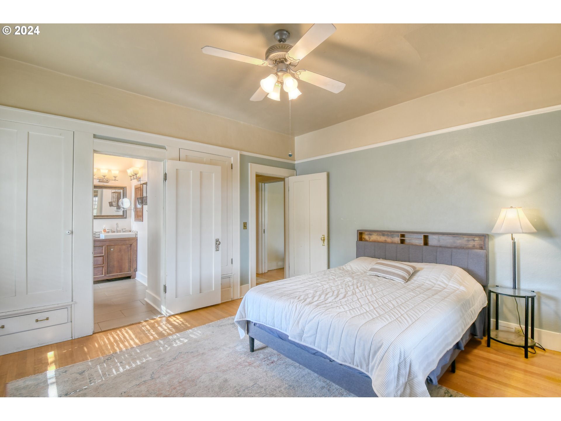 421 North Main Street Pendleton, OR 97801 - Photo 19 of 48 a spacious bedroom with a bed and a chandelier