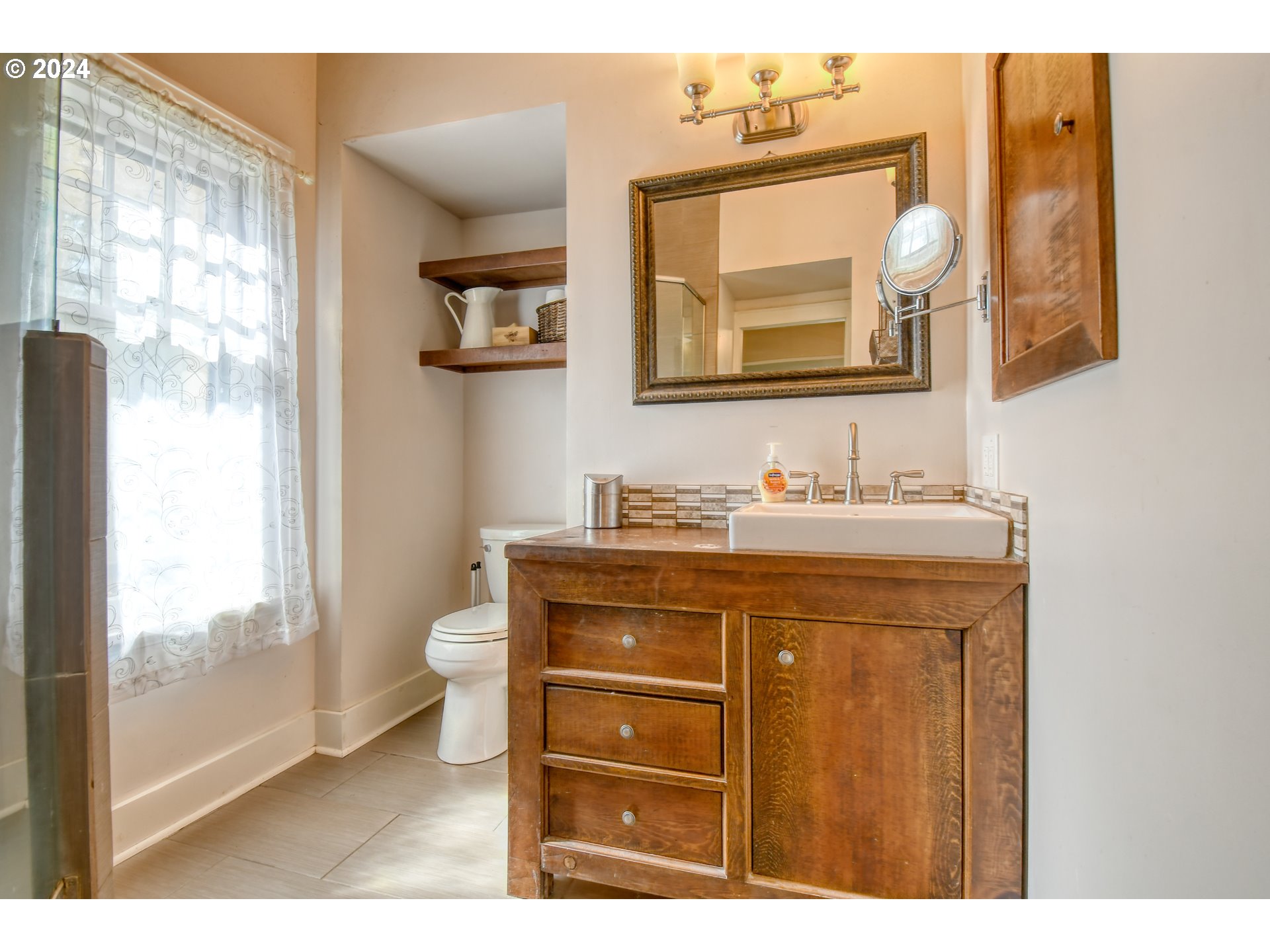 421 North Main Street Pendleton, OR 97801 - Photo 20 of 48 a bathroom with a toilet a sink a vanity a mirror and window