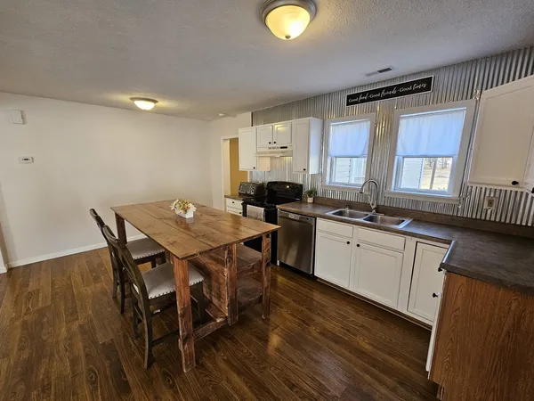 a kitchen with a table chairs sink and cabinets