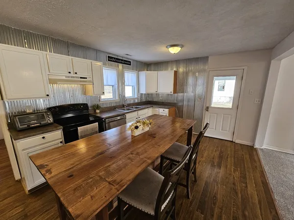 a kitchen with a table chairs a stove a sink and dishwasher