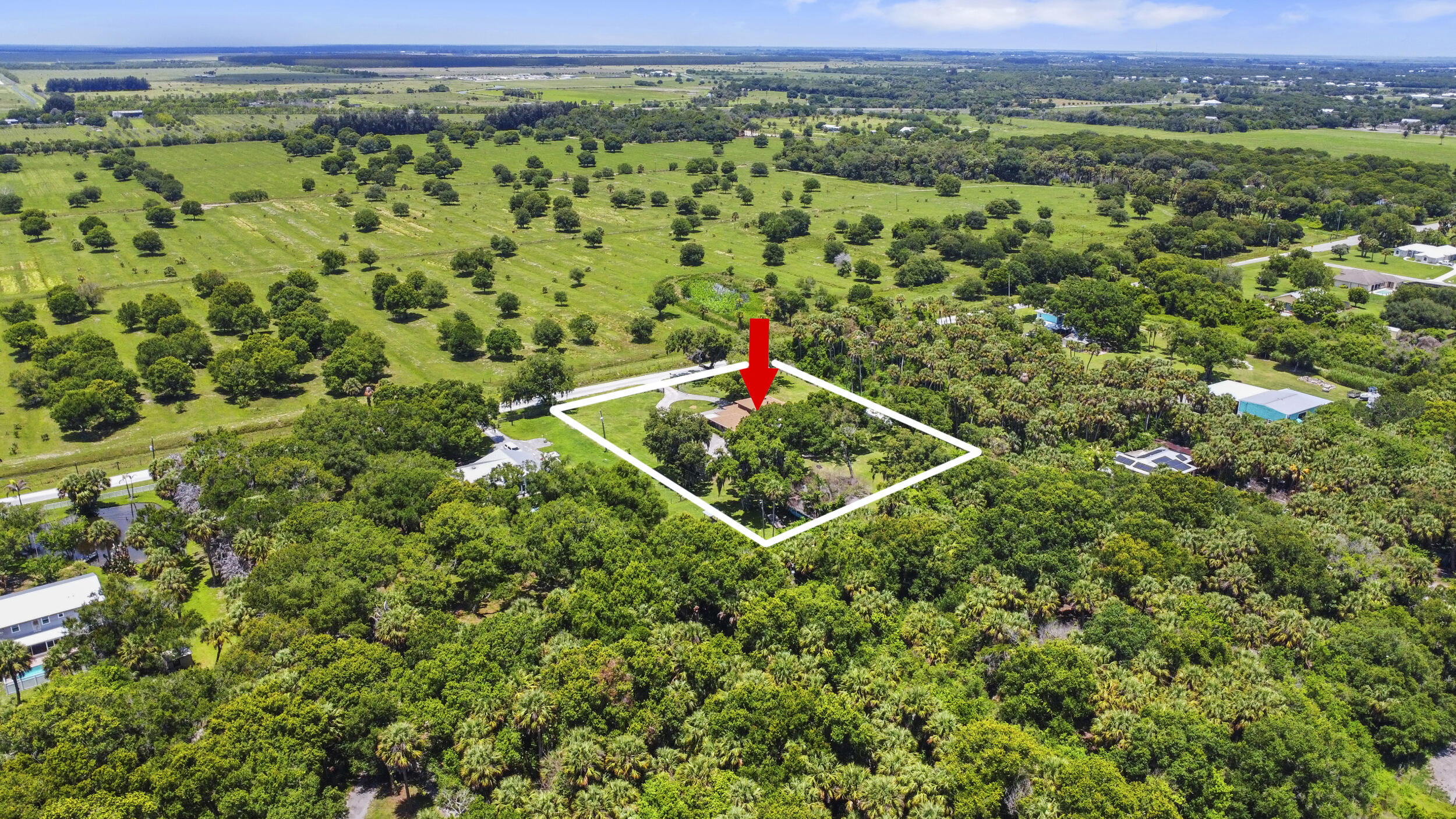 4170 McCarty Road Fort Pierce, FL 34945 - Photo 56 of 57 a view of a lush green field with a houses in the background