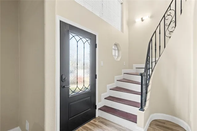 a view of entryway and hall with wooden floor