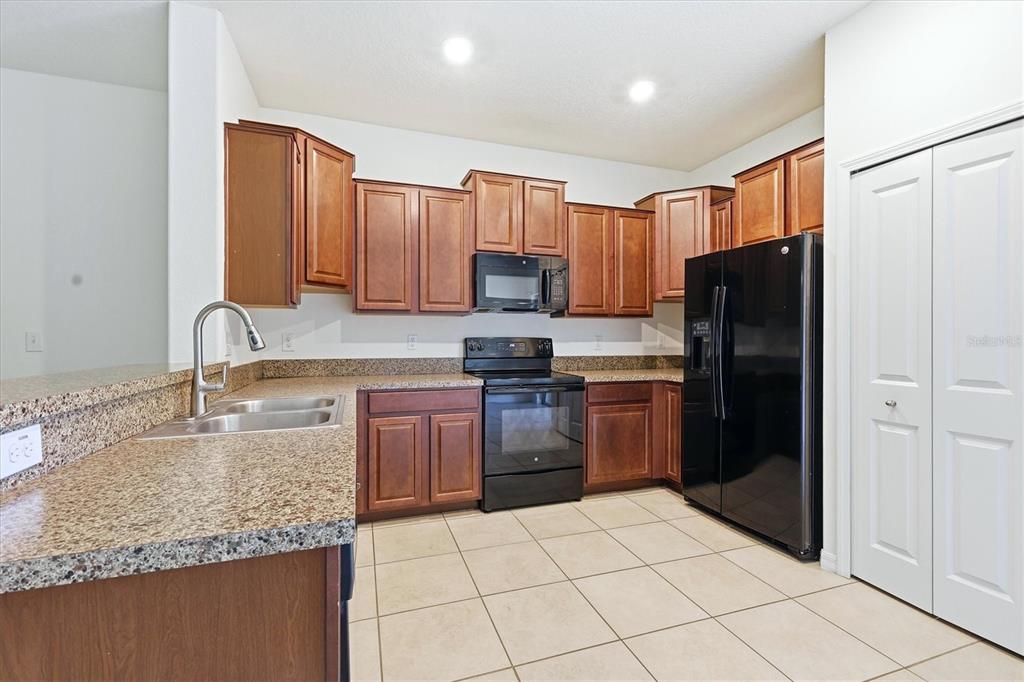 12909 Dream Catcher Way Riverview, FL 33579 - Photo 12 of 32 a kitchen with a refrigerator sink and cabinets