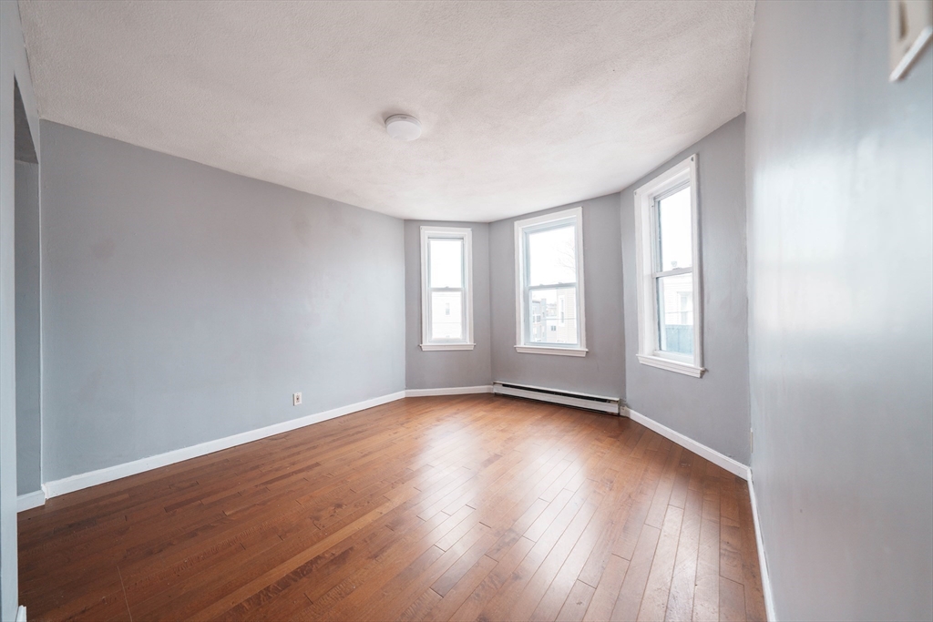 37 Maverick Street Chelsea, MA 02150 - Photo 11 of 25 a view of an empty room with wooden floor and window