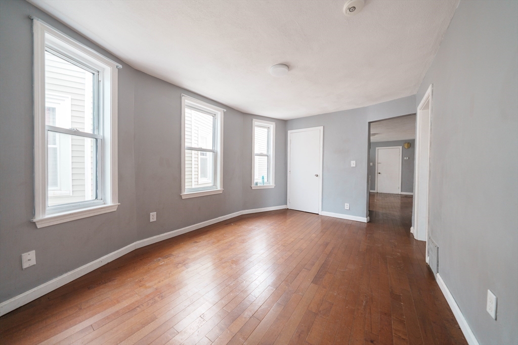 37 Maverick Street Chelsea, MA 02150 - Photo 2 of 25 a view of an empty room with wooden floor and a window