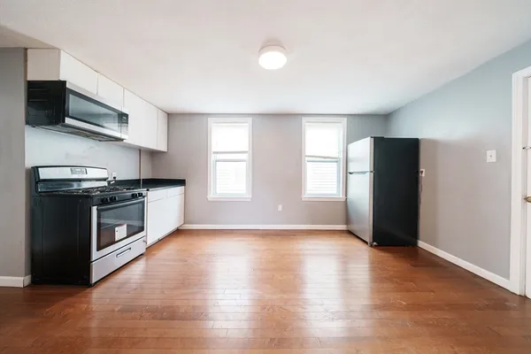 a kitchen with granite countertop a refrigerator and a stove top oven