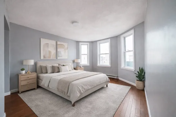 a bedroom with a large bed chandelier and a window