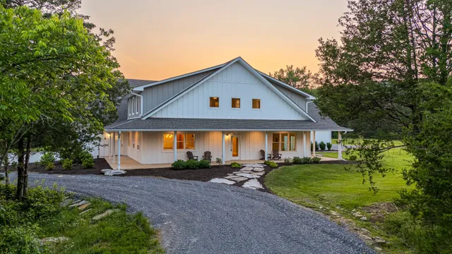 a front view of a house with a yard and potted plants