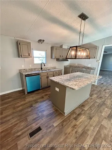 a living room with stainless steel appliances granite countertop furniture wooden floor and a kitchen view