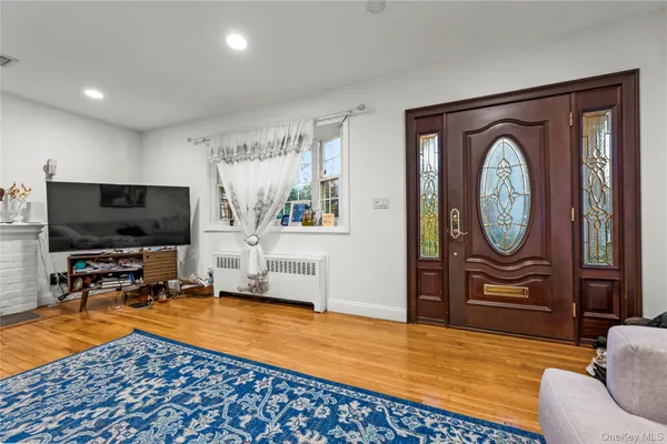 a living room with furniture a flat screen tv and kitchen view