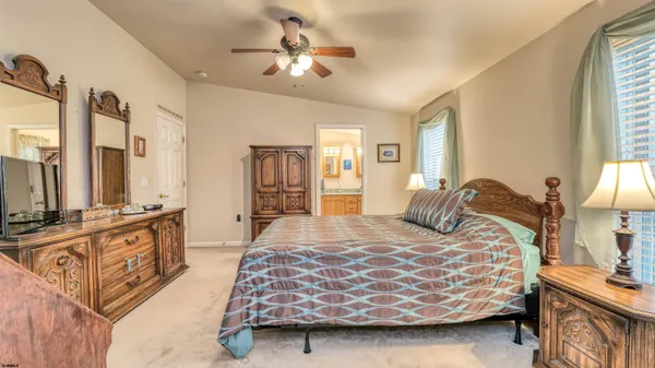 a bedroom with a bed a chandelier and dresser