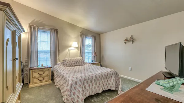 a bedroom with a bed and large windows