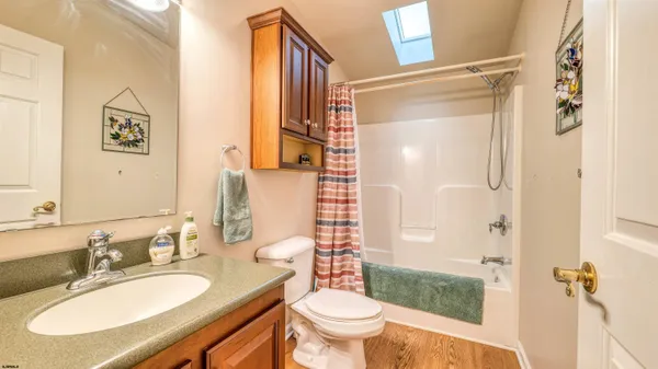 a bathroom with a granite countertop sink toilet a mirror and shower