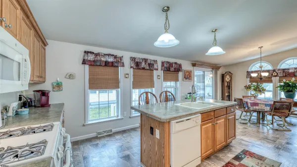 a kitchen with a sink stove and wooden floor