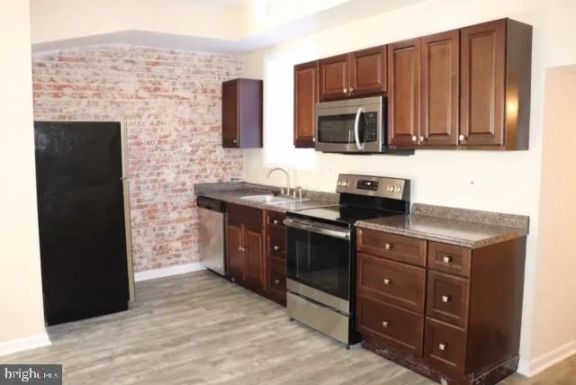 a kitchen with stainless steel appliances granite countertop a stove microwave and cabinets