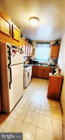 a kitchen with stainless steel appliances granite countertop a refrigerator a stove and a sink