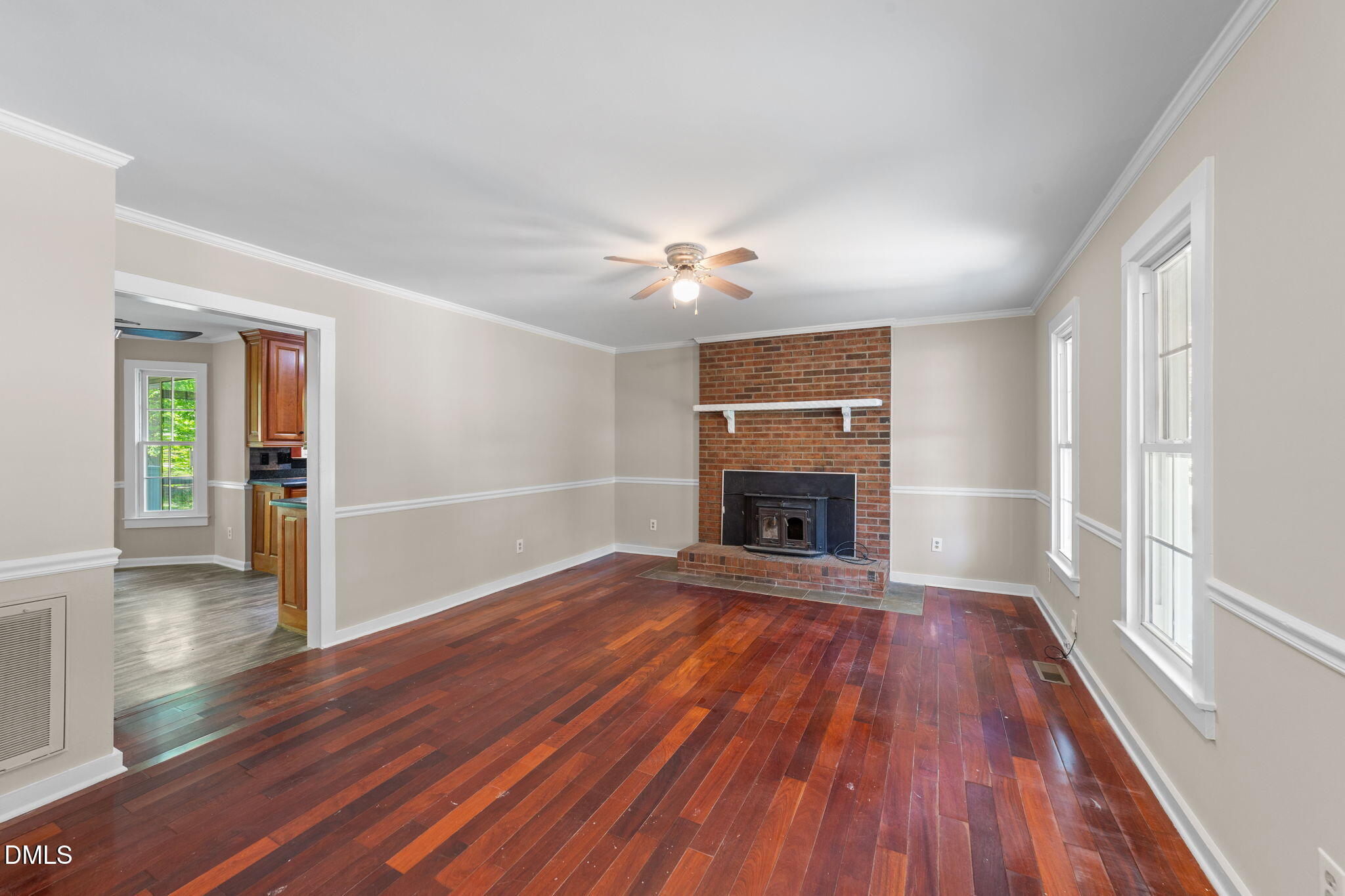 804 Olive Street Apex, NC 27502 - Photo 16 of 40 an empty room with wooden floor fireplace and windows