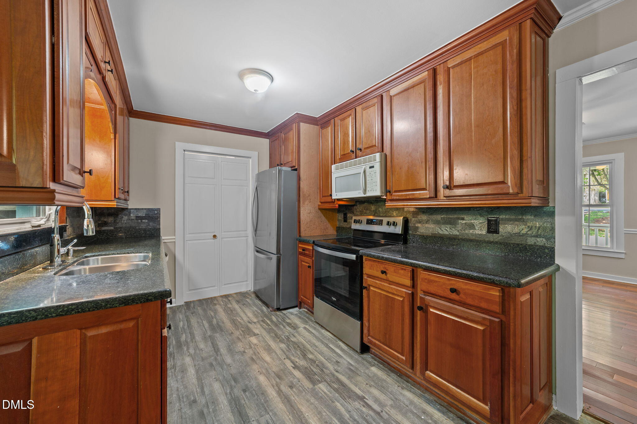 804 Olive Street Apex, NC 27502 - Photo 24 of 40 a kitchen with stainless steel appliances granite countertop a stove a sink dishwasher a refrigerator and cabinets with wooden floor