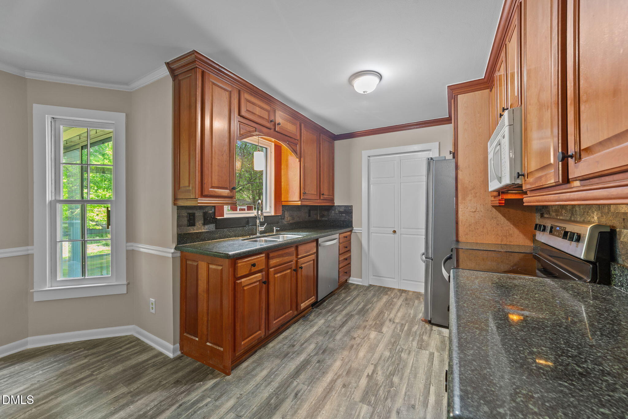 804 Olive Street Apex, NC 27502 - Photo 25 of 40 a kitchen with stainless steel appliances granite countertop a stove a sink and a refrigerator