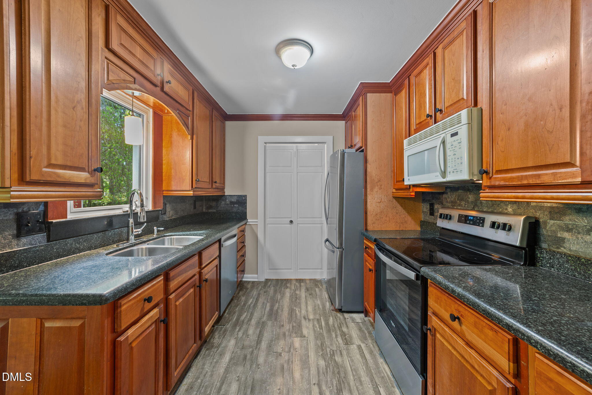 804 Olive Street Apex, NC 27502 - Photo 26 of 40 a kitchen with stainless steel appliances granite countertop a sink stove and cabinets