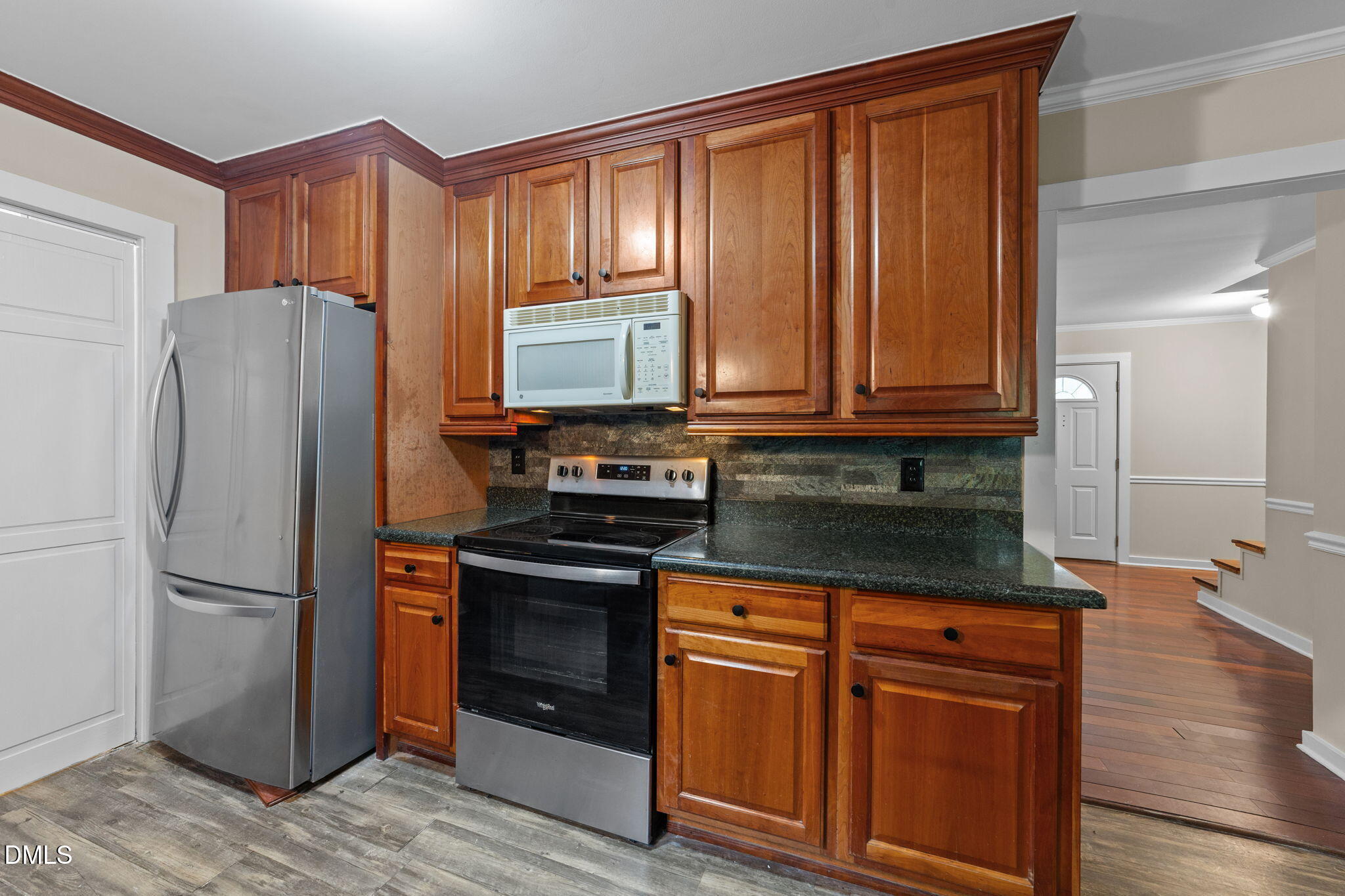 804 Olive Street Apex, NC 27502 - Photo 28 of 40 a kitchen with granite countertop wooden cabinets and stainless steel appliances