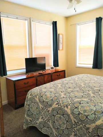 a bedroom with a bed and next to a window