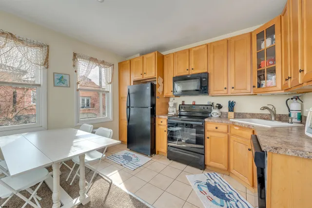 a kitchen with granite countertop a refrigerator stove top oven and sink