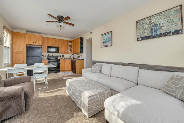 a living room with furniture and a view of kitchen