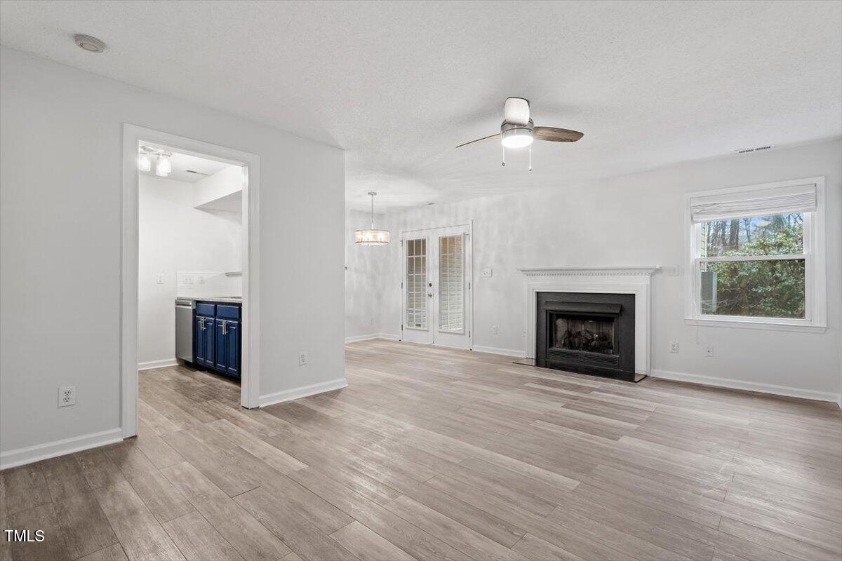 3307 Tarleton West, Unit A4 Durham, NC 27713 - Photo 17 of 40 an empty room with windows fireplace and a kitchen view