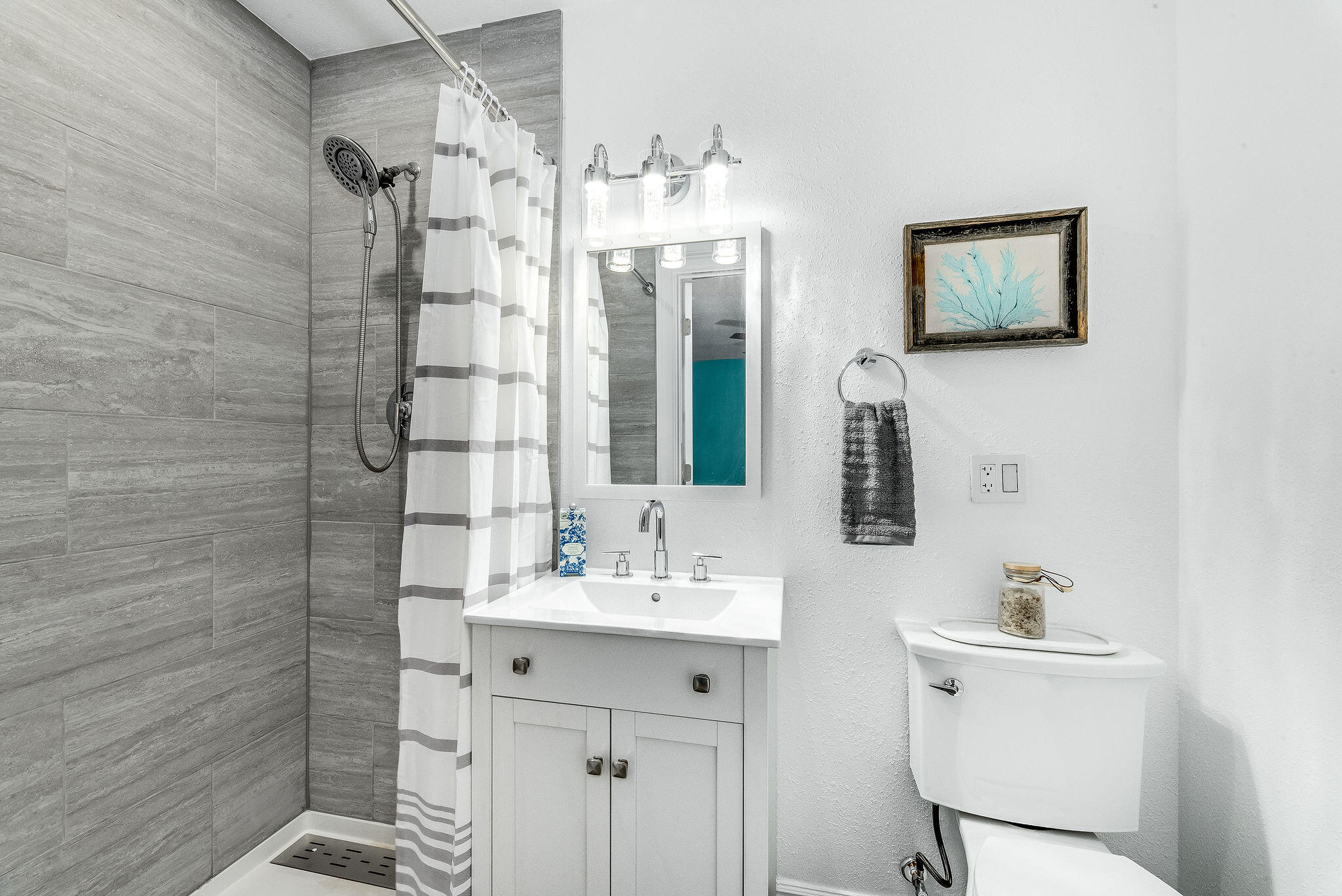 411 4th Street Merritt Island, FL 32953 - Photo 15 of 26 a bathroom with a sink a mirror a vanity and a shower