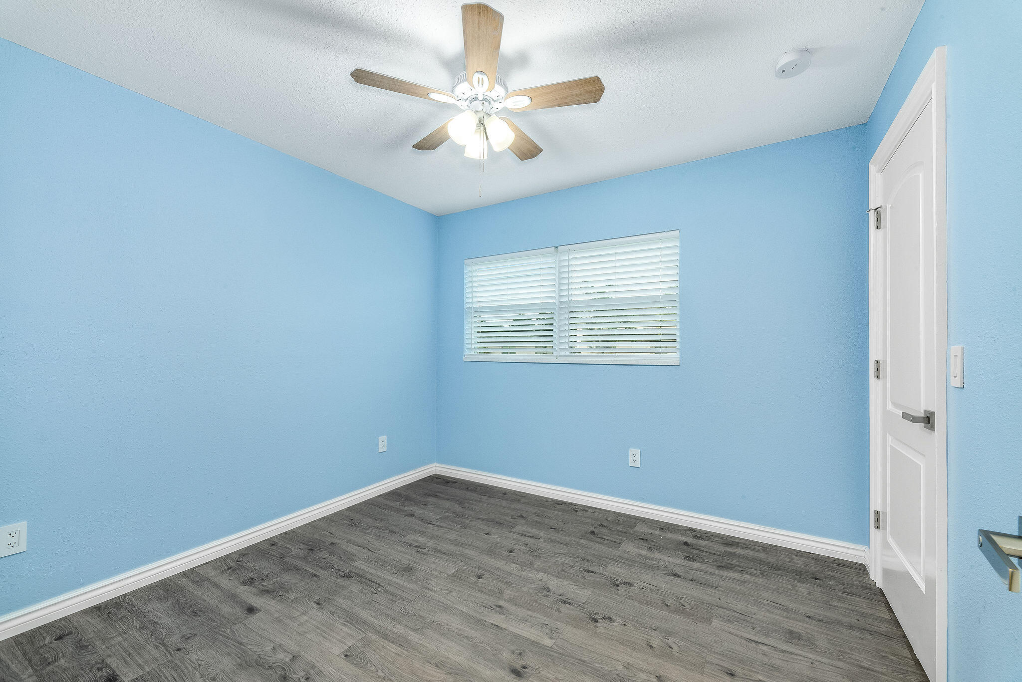 411 4th Street Merritt Island, FL 32953 - Photo 16 of 26 an empty room with wooden floor and ceiling fan