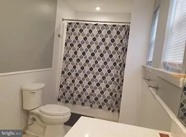 a bathroom with a toilet and a shower curtain