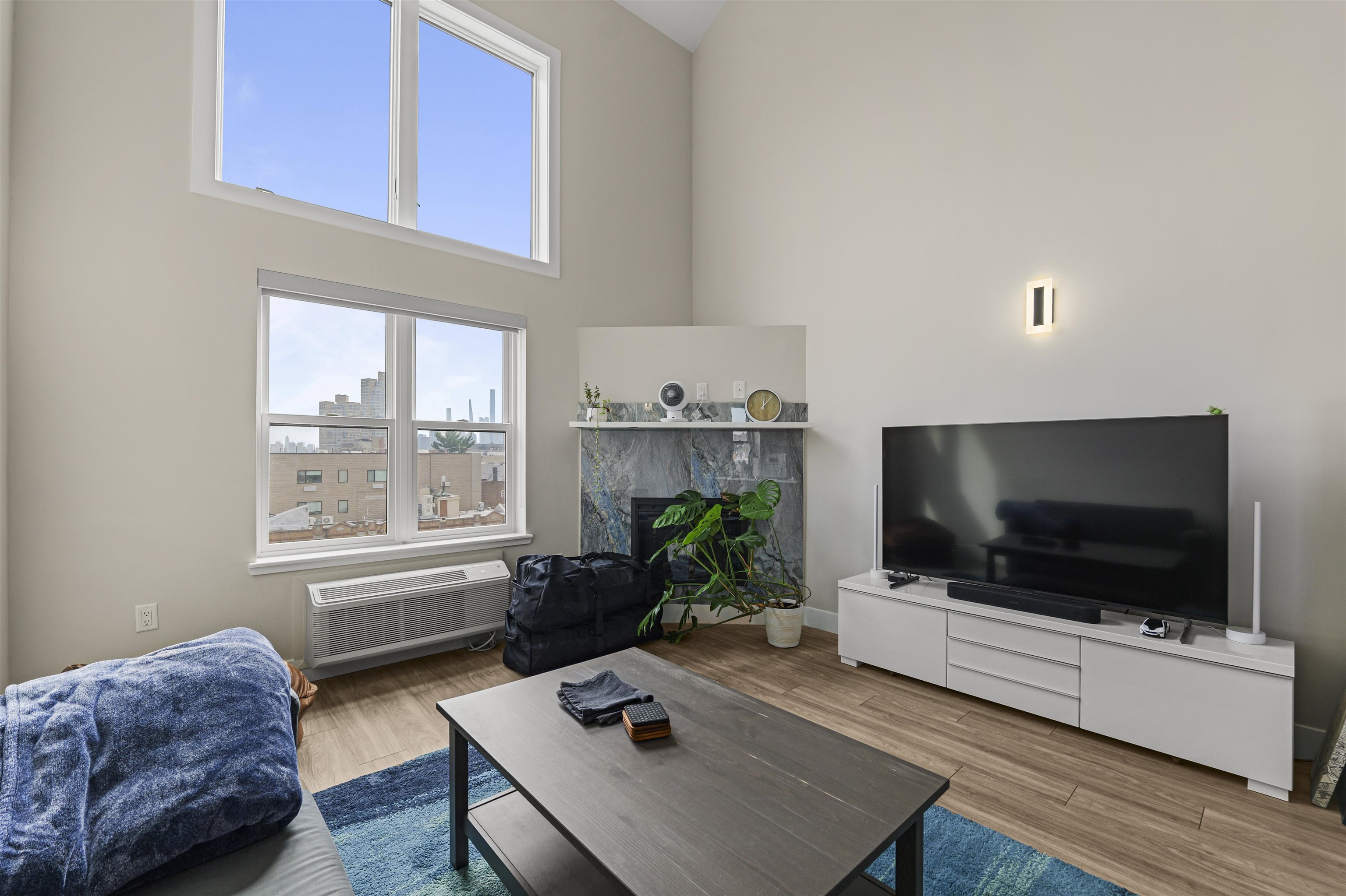 212 70th Street, Unit 404 Guttenberg, NJ 07093 - Photo 6 of 14 a living room with furniture and a flat screen tv